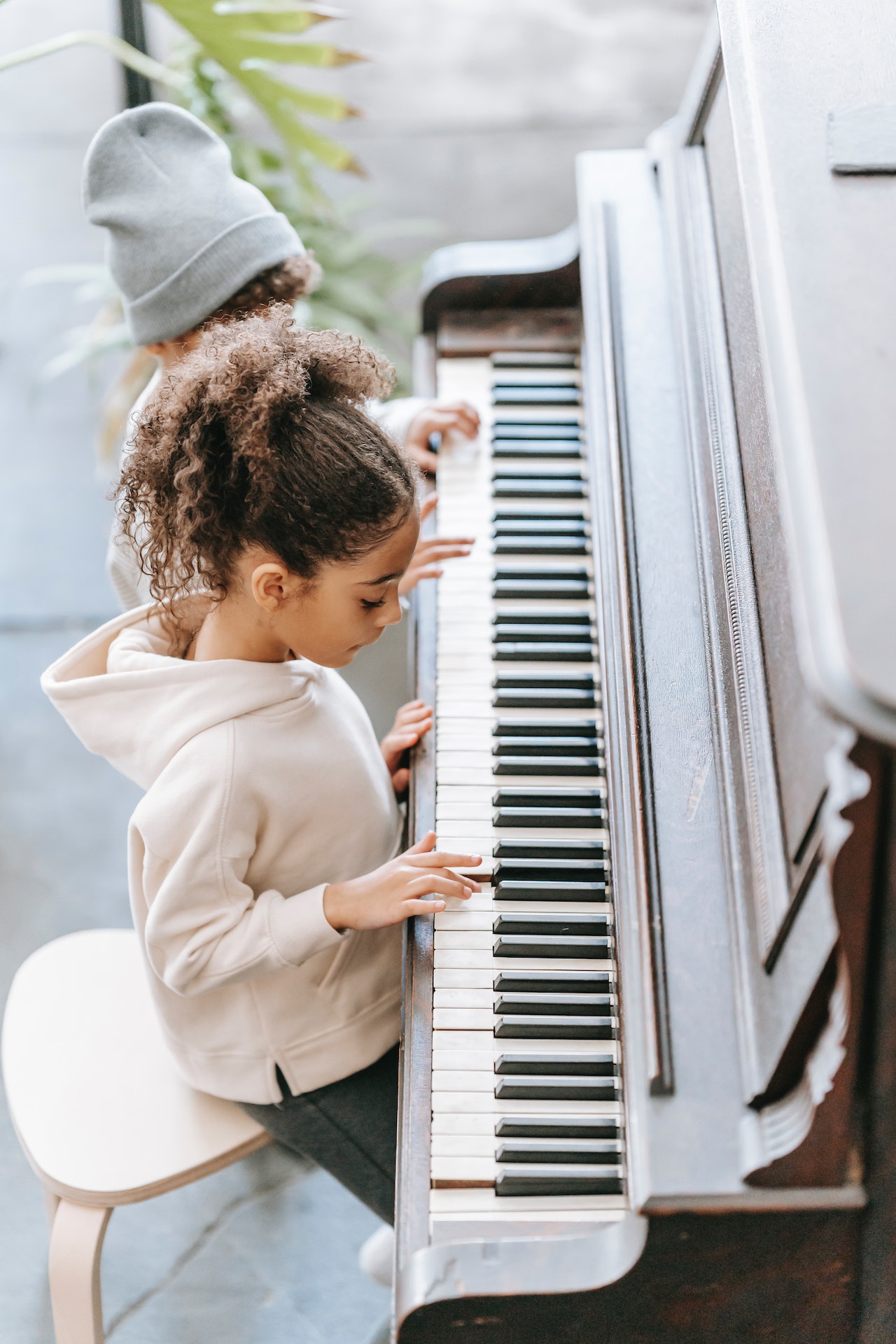 dziewczynka w bluzie gra na fortepianie